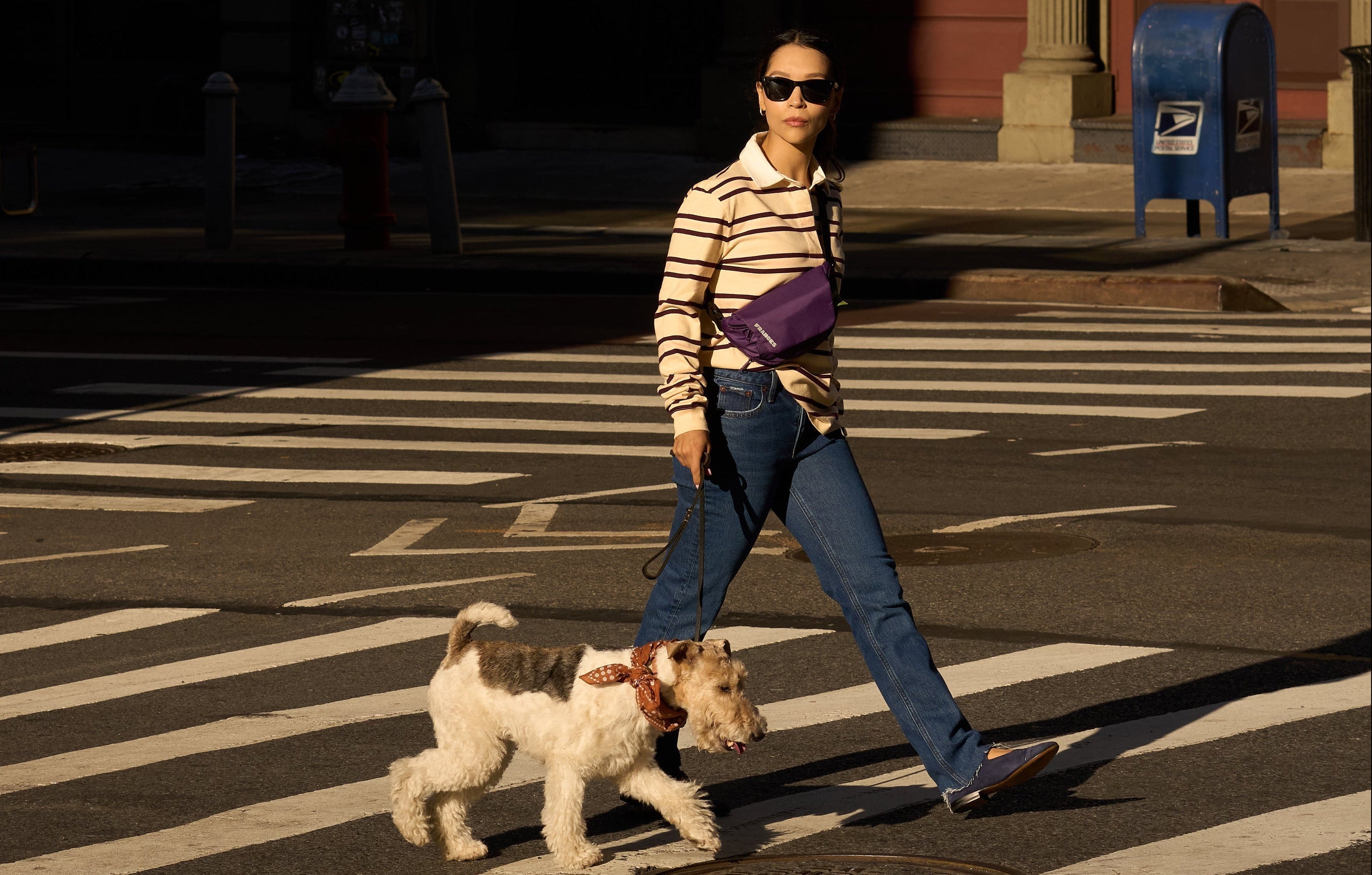 woman walking with dog on street wearing playwalk bag